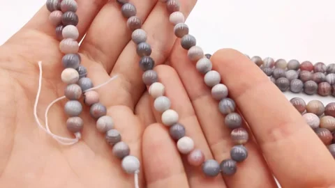Natural striped agate gemstone round beads polished for jewelry design projects Stock Footage 345139675