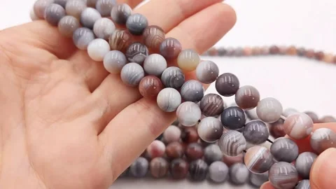Natural striped agate gemstone round beads polished for jewelry design projects Stock Footage 345139676