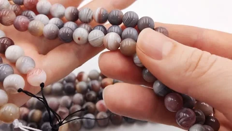 Natural striped agate gemstone round beads polished for jewelry design projects Stock Footage 345139679