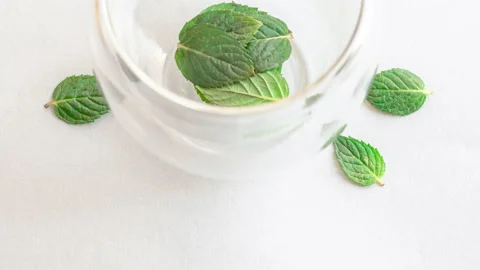 Natural tea mint leaves to double wall glass,pouring hot water tea infusion Stock Footage 206472111