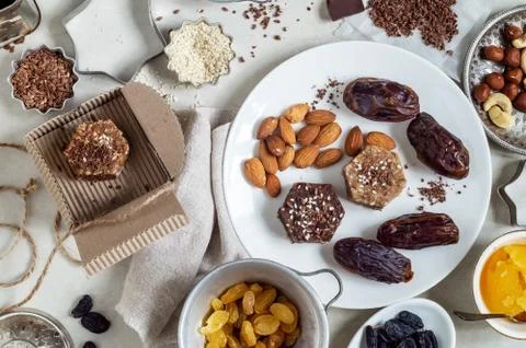 Natural useful sweets from dates, nuts, honey and raisins on a white plate Stock Photos