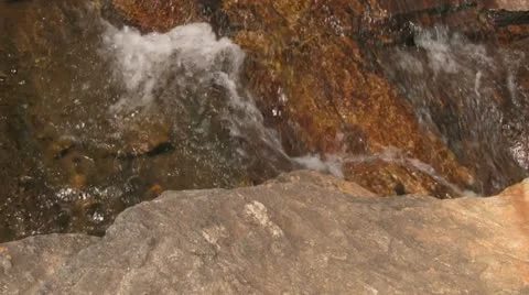 Natural Water Flow Over Rocks with Greenery in Foreground Stock Footage 12761354