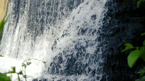 Natural waterfall cascading down a dark rock Stock Footage 345550852