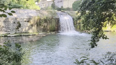 Natural waterfall that flows into a clear body of water Stock Footage 343628175