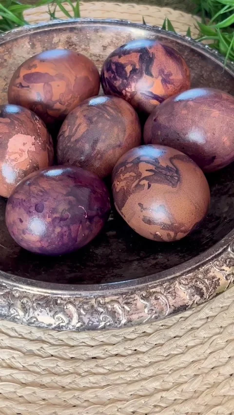Naturally dyed Easter eggs in an ornate silver bowl, featuring marbled brown Stock Footage 335923509