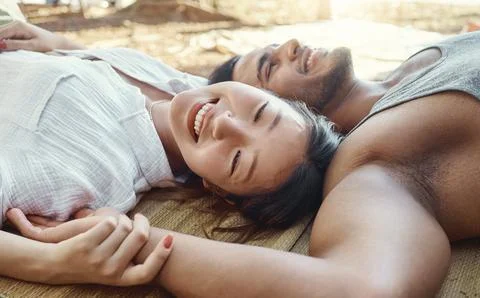 Nature allows us to connect deeper. a young couple lying down and bonding during Fotos Stock