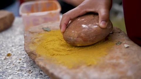 Nature Art; Child Using A Rock And Pedestal To Grind Down Yellow Pigment. Stock Footage 249519829