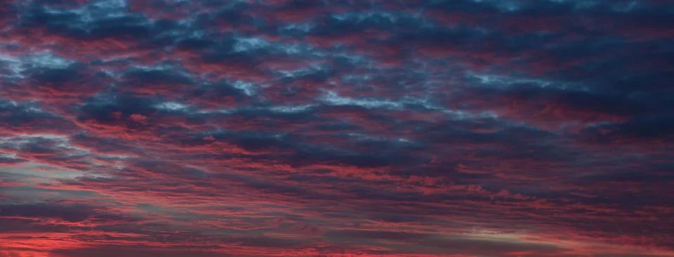 Nature background. Dramatic clouds on the sky in red and purple colors. Stock Photos