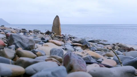 Nature background with large piece of rock on sea wild beach among stones. Stock Footage 116366825