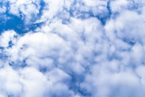 Nature background. White clouds over blue sky. Blue sky with clouds and sun. Stock Photos