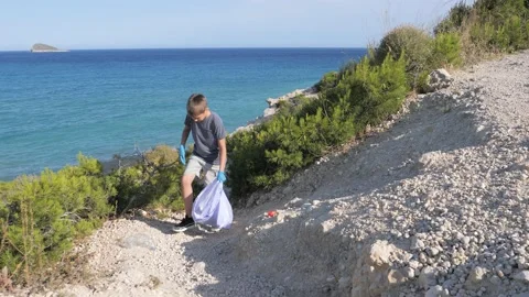 Nature cleaning, stop plastic, environmental concept. Volunteer kid raises and Stock Footage 131497498