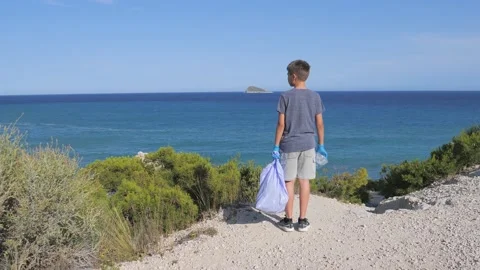 Nature cleaning, stop plastic, environmental concept. Volunteer kid raises and Stock-Footage 133409207