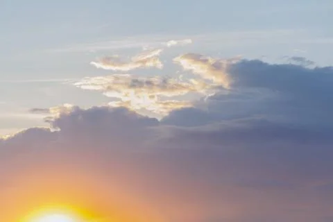 Nature. A dramatic cloud of blue above which you can see the orange sun in th Stock Photos