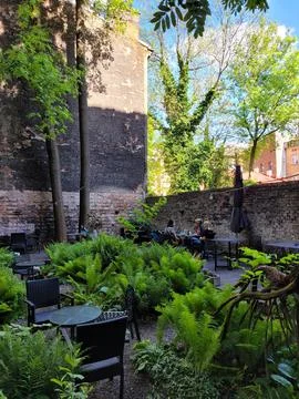 Nature friendly backyard of a restaurant with chairs and tables for dining Stock Photos