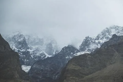 Nature landscape view of clouds covered snow capped mountains, Pakistan. Stock Photos