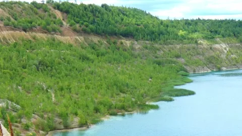 Nature view of a lake surrounded by green hills and trees in summer 動画素材 340448106