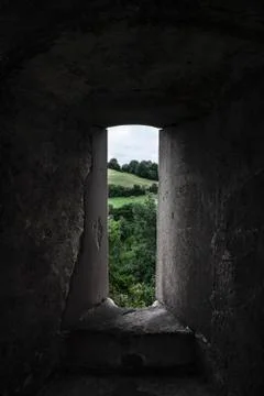 Nature view through an old stone window. Low light image Stock Photos