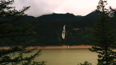 Nature's Dramatic Dance: Thunder Falls Merging with Kinbasket Lake on a Stock Footage 244121927