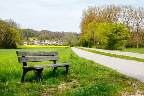 Nature's Rest Stop: A Bench Alongside a Pedestrian Trail and Road in Bavaria Stock-Fotos