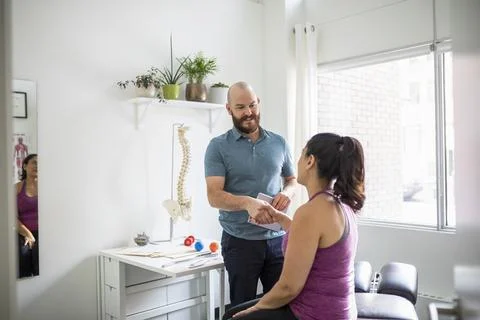 Naturopathic practitioner and client shaking hands in natural medicine treatment Stock Photos