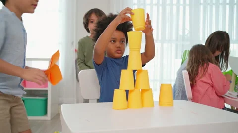 Naughty boy  falling cup stack and African boy feeling angry Stock Footage 188810175