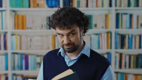 Naughty caucasian bearded guy taking pictures inside book on smartphone cheating Stock Footage 127724374