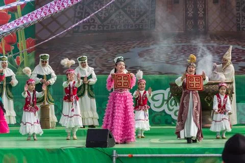 Nauryz holiday. Dancing with a patchwork blanket in hands. Stock Photos
