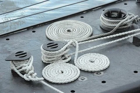 Nautical ropes coiled on ship deck, displaying maritime craftsmanship Stock Photos