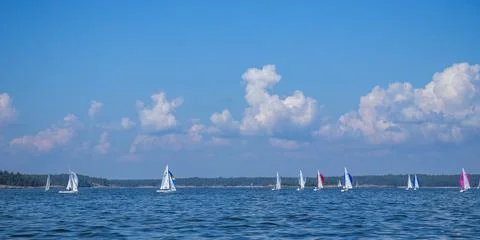 Nautical scene of sailing regatta with multiple yachts racing along the horiz Stock Photos