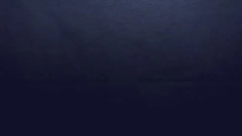Navy blue denim fabric texture ripples gently under cinematic soft spotlight cre Stock Footage 337550487