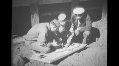 Navy Chief watching two army sergeants soldering on board beside building Stock Footage 37596373