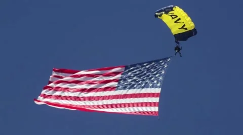 Navy paratrooper flying through the sky with huge American flag Stock Footage 56739300