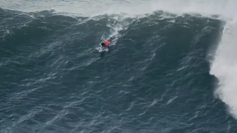 Nazaré, Portugal, 3 March 2020: A surfer paddles to catch the wave Stock Footage 149112505