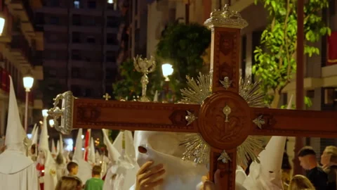 Nazarenos processing with a large cross during Holy Week Stock Footage 334854505