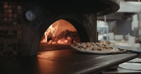 Neapolitan pizza being placed into a brick oven open flame Stock-Footage 105309653