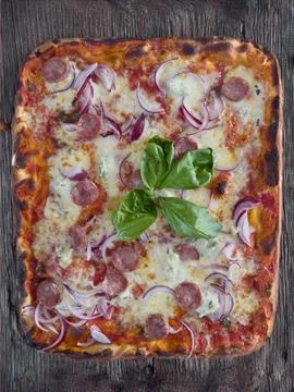 Neapolitan rectangular pizza with tomatoes, mozzarella, onions and sausage Stock Photos