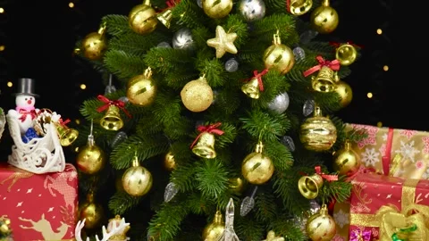 Near Christmas tree, a small tree surrounded by pine cones rotates on a stand Stock Footage 260887968