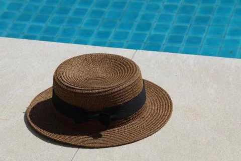 Near the pool is a straw hat Stock Photos