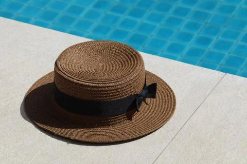 Near the pool is a straw hat Stock Photos