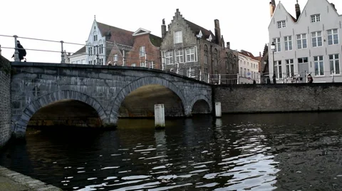 Near water level. View of a bridge and houses in Bruges, Belgium. Walkers &amp; cars Stock Footage 45263200