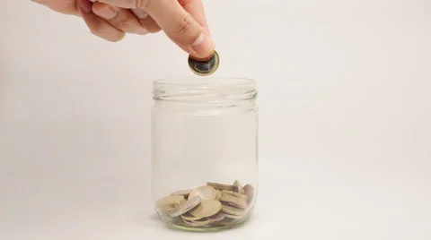 Nearly empty jar with coins throwing hands inside and saving Vidéo 37818678