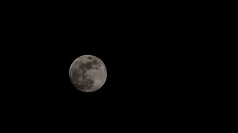 Nearly full moon rising with wispy cloud passing over in early spring Stock Footage 331697675