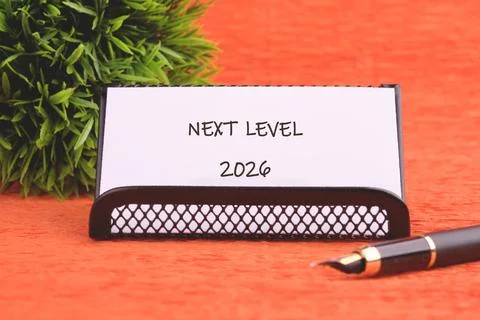 A neat desk setup featuring a sign that reads Next Level, symbolizing goals for Stock Photos