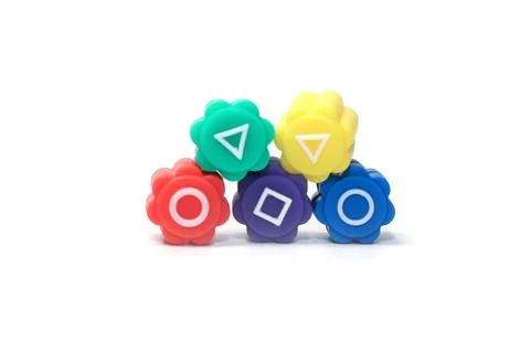 Neat pyramid stack of five colorful flower-shaped plastic tokens displaying.. 写真素材