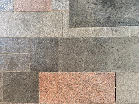 A neat row of rectangular tiles, varying in color gray, brown, red, black a.. Foto stock