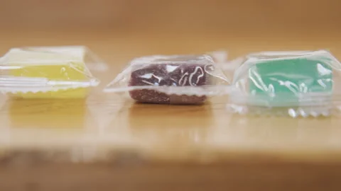 Neat row with wrapped items. Closeup of polished plastic reflections and Stock Footage 341769490