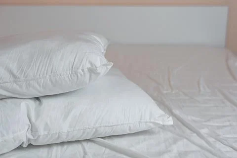 Neat stack of bedding pillows and a duvet lie on the bed Stock Photos