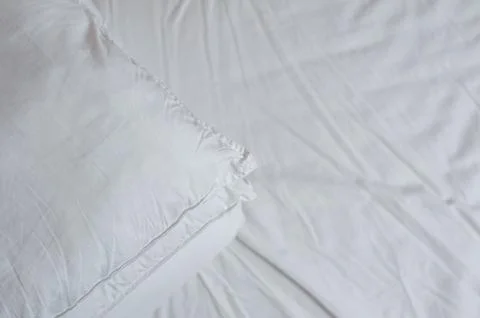 Neat stack of bedding pillows and a duvet lie on the bed Stock Photos