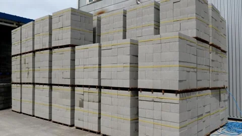 A neat stack of concrete blocks, secured with bright yellow tape, ideal for Stock Footage 312811344