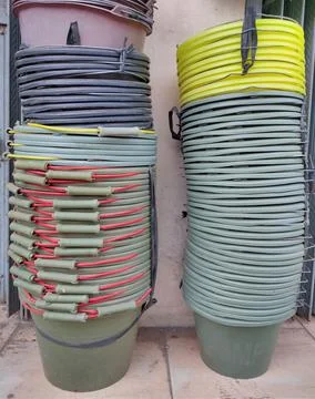 Neat stack of multi-colored buckets in a builder's shop Foto stock